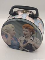 Front view showing Lucille Ball and Vivian Vance image, handle and latch