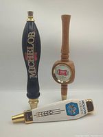 Group shot of three beer tap handles: Michelob, Miller High Life, Molson Golden