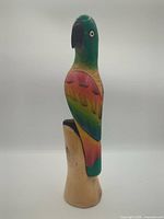 full view of wooden parrot on base