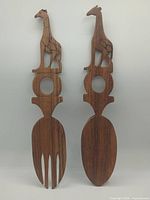 Front view of both salad servers showing giraffe handles and overall shape