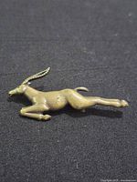 Front view of brass antelope brooch