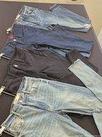 Four pairs of jeans laid out showing colors and styles