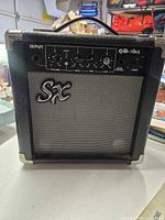 Front view showing SX logo, grille, control panel with knobs and jacks