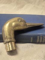 Full view of brass duck head handle on book background