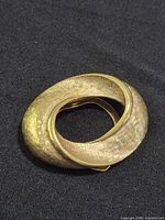 Front view of textured gold-tone brooch