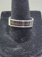 Ring on display cone showing brown inlay and silver band