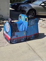 Front three-quarter view of pop-up train tent showing Thomas face and overall design