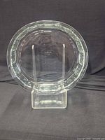 Front view of clear pressed glass octagonal plate on stand