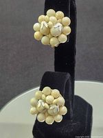 Front view showing both cream bead cluster earrings on stand