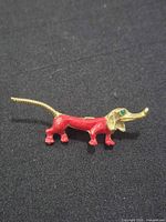 Front view showing red enamel dachshund brooch with green eye