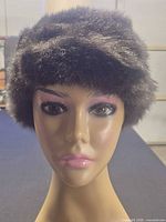 Front view of dark brown faux fur pillbox hat on mannequin head