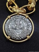 Close-up of round pendant showing raised design and rhinestone accents
