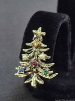 Front view of one earring showing tree shape and stones