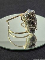 Side view of gold-tone cuff showing full quartz cluster and band design