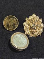 All three gold-tone pins displayed together