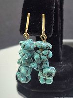 Front view of both earrings showing turquoise nuggets and gold-tone hooks
