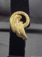 front view of one gold-tone swirl clip-on earring