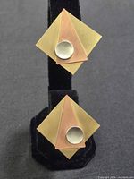 Front view showing two angles of decorative geometric metal top on brass clip