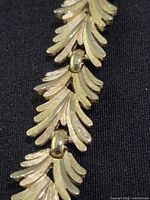 Close-up of leaf motif links and gold-tone finish