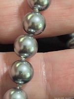 Close-up of gray faux pearl beads showing surface