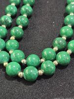 Close-up of green round beads and gold-tone spacers