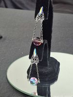 Full view of dangle chandelier earring on stand showing overall design and length
