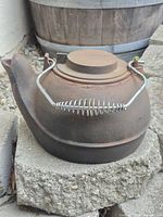 Full view of cast iron kettle showing lid and bail handle