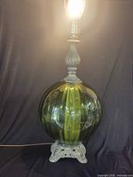 Full view of green art glass lamp illuminated