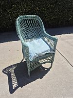 Front view of light turquoise wicker rattan armchair with cushion