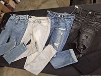 Four pairs of jeans laid out showing colours and overall condition