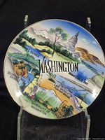 Front view of porcelain Washington State souvenir plate with landmark illustrations and gold rim