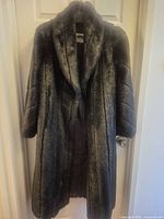 Front view of dark brown faux fur full-length coat on hanger