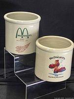 Both stoneware crocks on display stand