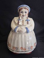 Front view of ceramic girl cookie jar showing lid and full body