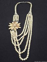 Full view showing multi-strand bead bracelet with carved flower and clasp