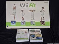 Boxed Wii Fit balance board with two game cases displayed