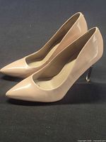 full view of both nude patent pumps side by side