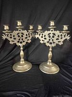 Full view of both brass three-arm candelabra