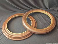 Front view of both round wooden frames with brass trim