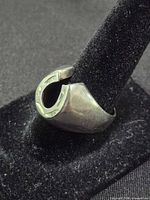 Side view of pewter horseshoe ring on display stand
