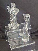 Both clear glass angel figurines on acrylic riser