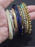 Hand holding all ten bangles stacked