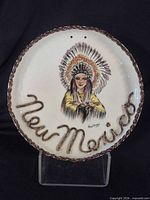 Front view of signed New Mexico ceramic plate showing Native American chief illustration and raised lettering