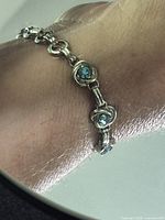 Bracelet on wrist showing central blue crystal station and link detail