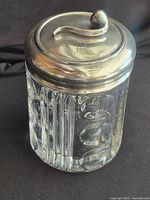 Full view of jar showing glass body and metal lid