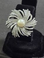 Single earring front view showing swirl design and pearl