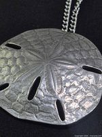 front close-up of hammered pewter sand dollar pendant