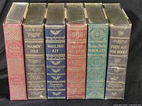 All six Dennison Handbook volumes standing with spines visible