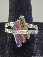 Front view of ring showing multicolour baguette stones and CZ-accented bands
