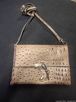 Front view of tan brown faux leather crossbody bag with strap